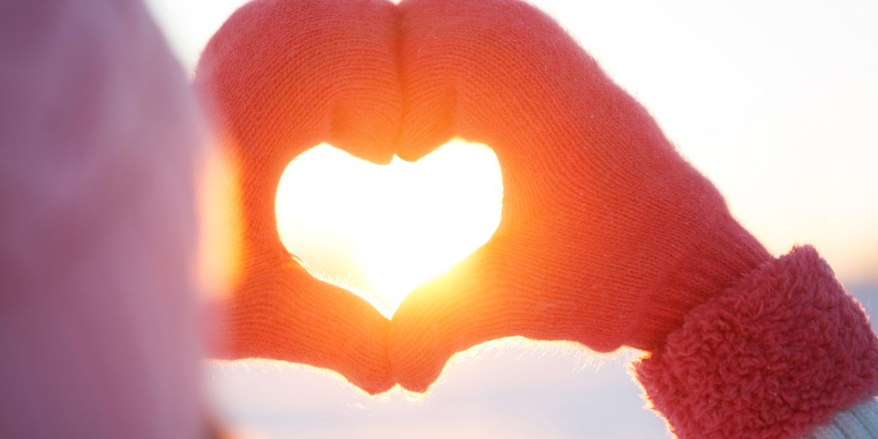 Woman hands in winter gloves Heart symbol