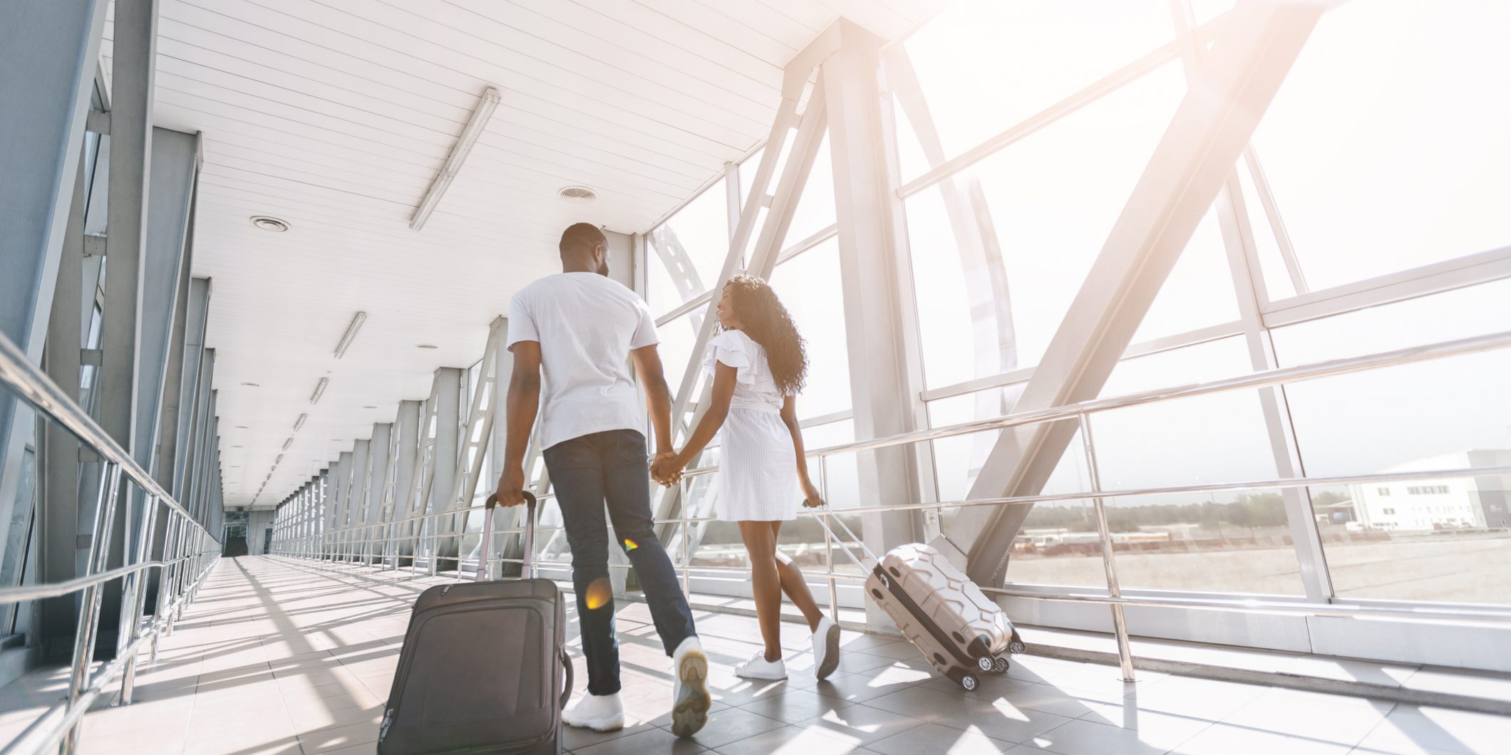 Imagem de um casal com malas andando pelo aeroporto